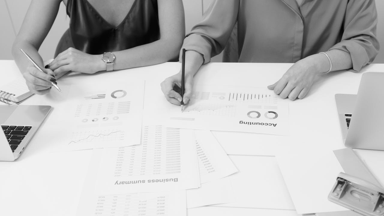 Two professionals analyzing financial documents in a modern office setting.