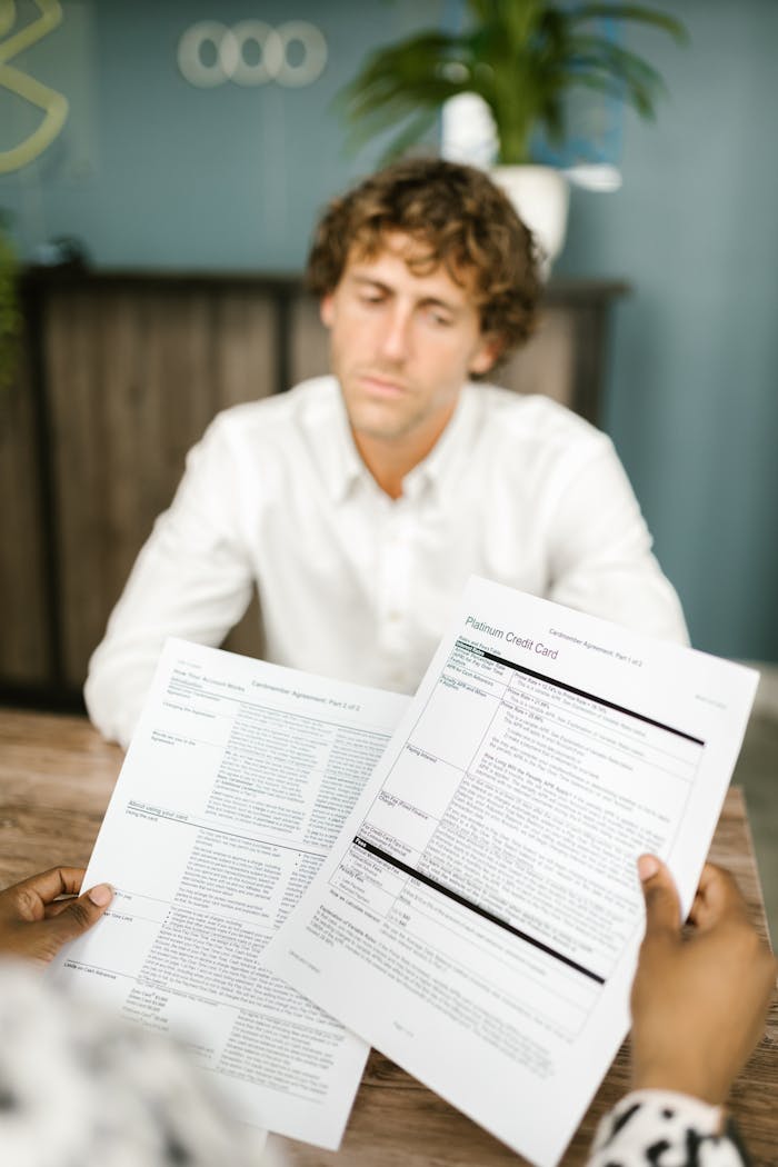 Professional man assessing financial paperwork in a modern office environment.